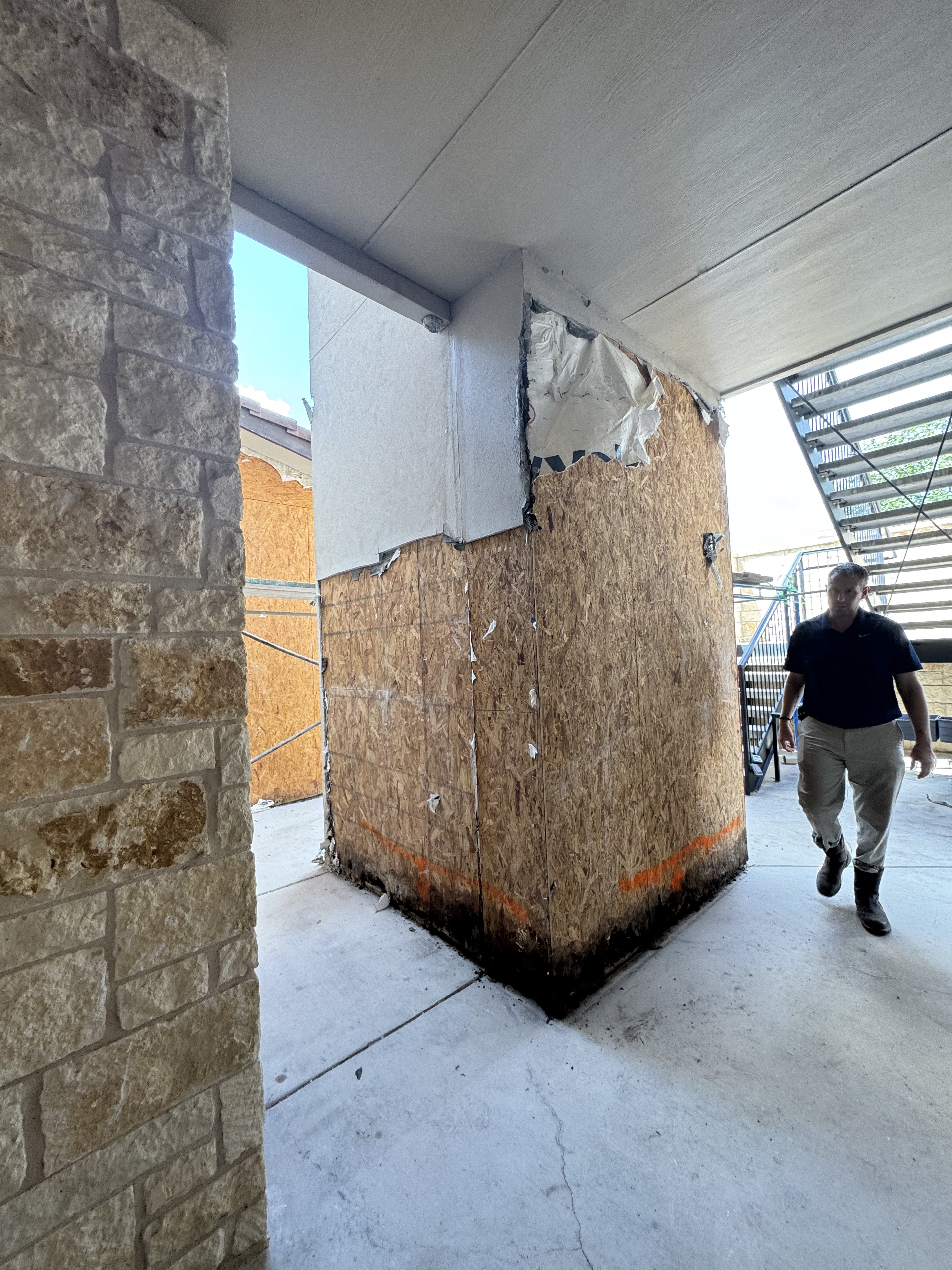Dark water damage visible along the bottom of exposed wood sheathing